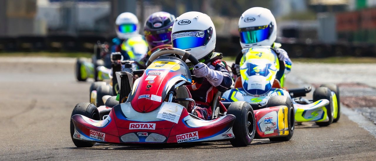 A pack of karts racing wheel to wheel on the RMC UAE grid